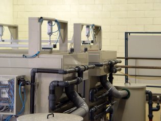 Skimming units for the treatment of water curtains in paint booths